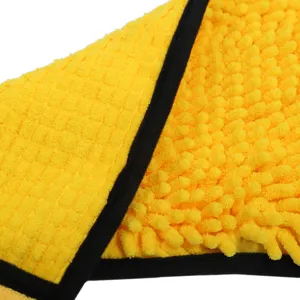 Detalle de toalla de chenilla amarilla para mascotas con textura suave y borde negro de secado.