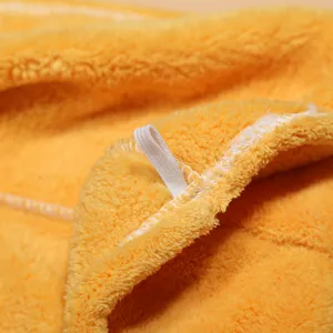 Coral fleece dry hair cap microfiber yellow towel close-up texture quick drying hair wrap.