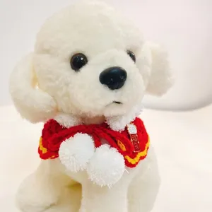 Detailed view of festive red knitted pet cape with white pompoms and lucky pendant, cute design.