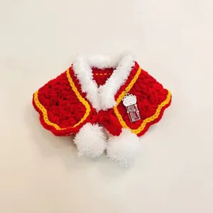 Red knitted pet Christmas shawl with white plush trim and pom poms, cute festive cat scarf.