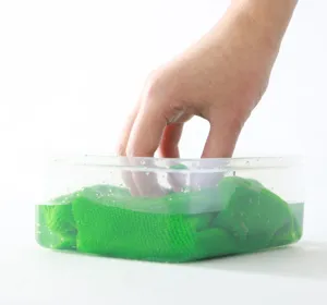 Paño de cocina de microfibra verde sumergido en agua para una limpieza muy potente.