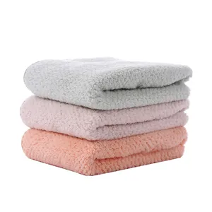 Vue détaillée de serviettes douces en polaire corail, textile de bain bien absorbant.