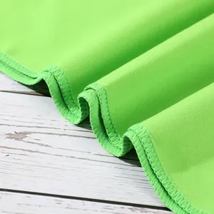 Bright green quick-drying cooling sports towel detail showing neat stitching and soft fabric texture.