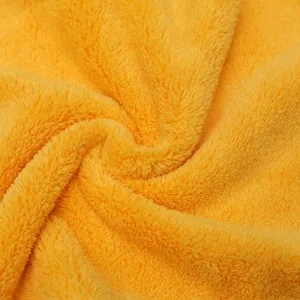 Detailed close-up of soft yellow coral fleece fabric, showing fluffy absorbent towel texture.