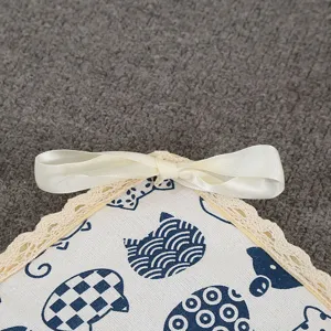 Close-up detail of pet cooling mat featuring cute cat pattern, lace trim and white bow.