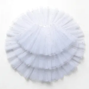Detailed view of girls white tutu skirt with star sequins and fluffy mesh layers.