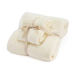 Luxurious soft coral fleece towel set with elegant gift ribbon packaging for home use.