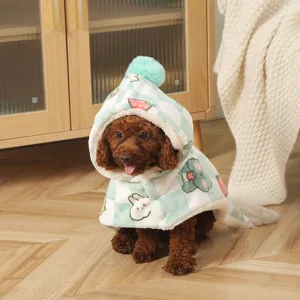 Cozy pet cloak detail view, green and white checkered design with cute cartoon animals for winter warmth.