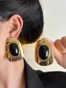 Vintage irregular gold metal earrings with black resin oval inlay, chic retro details.