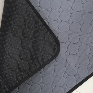 Detailopname van grijze huisdierenplasmat met antislip zwarte noppenachterkant en gewatteerd.