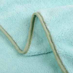 Soft coral fleece kids bath towel detail shot showing plush texture and neat edge binding.