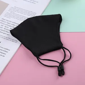 Dettaglio in primo piano della maschera facciale in tessuto nero con lacci regolabili.