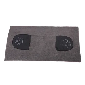 Detalle de toalla de microfibra gris para mascotas con bolsillos y bordado de huellas.