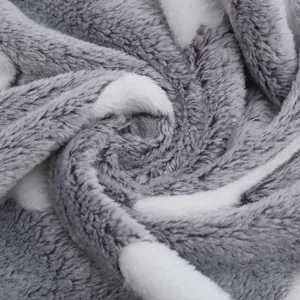 Soft plush pet blanket detail shot, grey and white fuzzy coral fleece material for warmth.