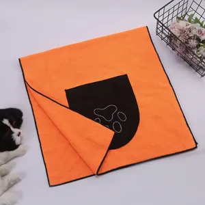 Toalla de microfibra naranja para mascotas con diseño de huella y bolsillo práctico.