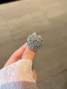 Primo piano dettagliato dell'anello in metallo con design testurizzato e complesso.