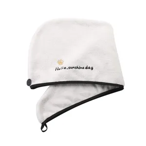 Détail de bonnet de bain en polaire corail blanche, serviette séchage rapide absorbante à bouton.