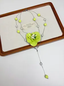 Detailed view of the layered green flower pearl necklace, elegant fashion jewelry accessory.