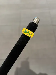 Detail view of a stylish yellow enamel ring with cute green floral design and adjustable band.