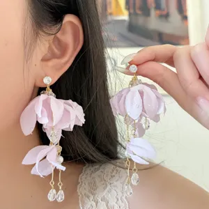 Elegant purple fabric flower earrings with sparkling rhinestones and delicate beaded dangles.