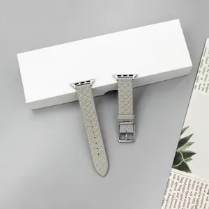 Detailed view of grey quilted leather watch band texture and metal buckle closeup shot.