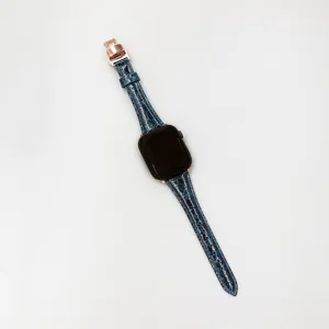 Blue crocodile pattern leather watch strap detail with rose gold clasp closeup view.