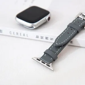Gedetailleerd overzicht van grijs lederen horlogeband voor Apple Watch, slank design met metalen gesp.