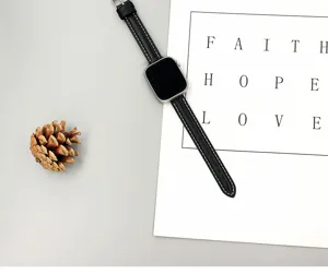 Vue détaillée du bracelet de montre fin en cuir noir avec de fines surpiqûres blanches.