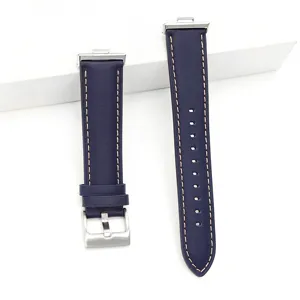 Detailed view of dark blue leather watch strap with contrast stitching and metal buckle.