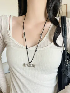 Dettaglio della collana con ciondolo a caramella argentata in stile coreano con cordino nero trendy.