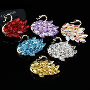 Dettaglio ravvicinato di ciondoli cigno in cristallo colorato e strass, accessori fai da te.