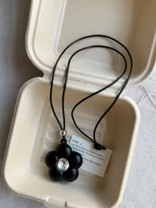 Black five-petal flower pendant necklace with crystal center and adjustable black cord fashion