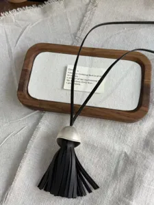 Long black leather tassel necklace with silver dome cap elegant chic pendant jewelry accessory.