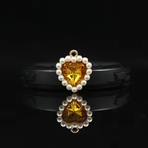 Detail view of the 18mm golden alloy heart pendant with sparkling yellow crystal and pearls.