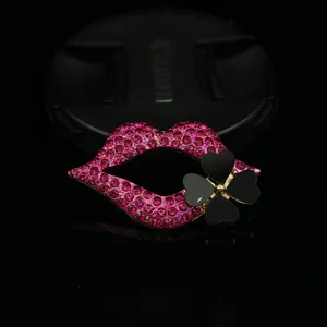 Nahaufnahme von Strass-Lippen mit schwarzem Kleeblatt-Anhänger für DIY-Handyhüllen-Schmuck.