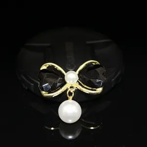 Close-up detail of a sweet bow pearl charm DIY jewelry accessory with black and gold tone.