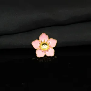 Primo piano di dettaglio dell'accessorio floreale DIY in smalto rosa con nucleo dorato.