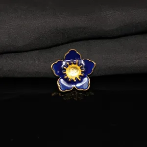 Dettaglio primo piano fiore smalto blu, pistillo dorato accessorio per fai da te creativo.