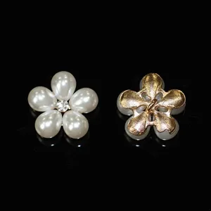 Detail shot of DIY pearl rhinestone flower button accessory, showing front petals and back metal shank.