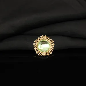 Close-up detail of vintage gold alloy filigree rhinestone round gemstone button DIY craft accessory