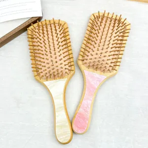 Detailed shot of bamboo paddle brushes with elegant marble-effect acetate handles.