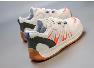Detailed macro view of breathable mesh children sneakers with orange accents and soft soles