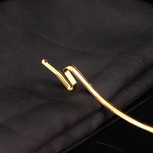Close-up detail of the gold-plated metal serpentine hairpin accessory with elegant S-curve.