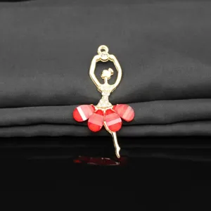 Close-up detail of a gold alloy and red crystal ballet dancer pendant for DIY jewelry crafts.