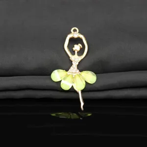 Close-up of a gold alloy ballet dancer pendant with sparkling rhinestones and green crystal.