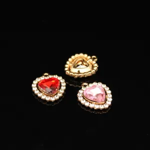Close-up detail view of colorful crystal heart alloy pendant charms for DIY jewelry making.