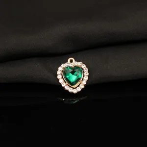 Close-up view of the green heart rhinestone pendant detail, shimmering crystal and alloy texture.