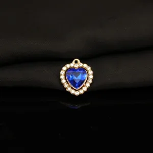 Detailed close-up of blue crystal heart pendant with rhinestone halo on black background.