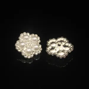 Detail view of alloy flower sewing buttons adorned with white pearls and sparkling rhinestones.