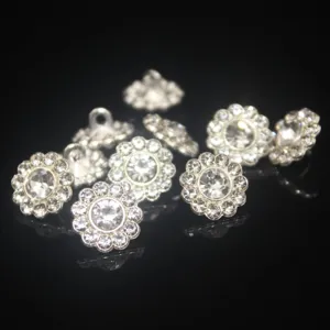 Close-up detail shot of sparkling rhinestone flower buttons, silver metal shank buttons for DIY crafts.